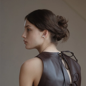 Elegant silver-plated ear cuff featuring a single pearl, shown on a female model