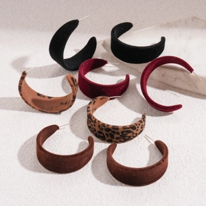 Detail of C-shaped flocked earrings in black, burgundy, brown, and leopard print styles