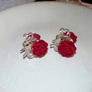 Pair of vintage red velvet rose hair clips with rhinestone leaves and heart-shaped grips