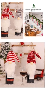 Detail von gestrickten Weihnachts-Zwerg-Weinflaschenhüllen mit gestreiften Mützen und Pelz