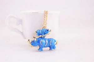 Detailed close-up of blue mother and child rhino charm with gold trim and sparkling crystals