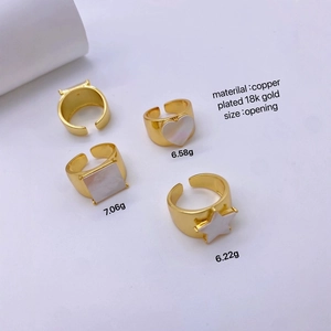 Detail view of 18k gold plated copper rings with star heart and square shell accents