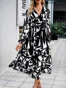 Detail of V-neck long sleeve dress featuring black and white geometric print patterns