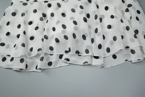Detail of double-layered ruffle hem on white polka dot chiffon halter dress