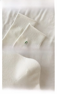Detail of white cotton socks showing elastic ribbed cuffs and reinforced heel texture