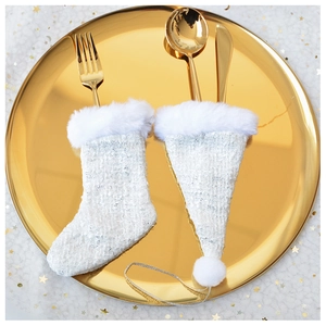 Close-up of white tweed Christmas cutlery holders with plush trim on a golden plate