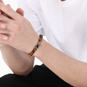 Close-up of tiger eye stone beads and silver Buddha head bead on a beaded bracelet