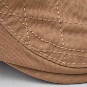 Close-up of diamond quilted stitching and texture on khaki canvas flat cap