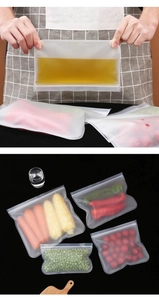 Various sizes of reusable silicone food storage bags filled with fresh vegetables