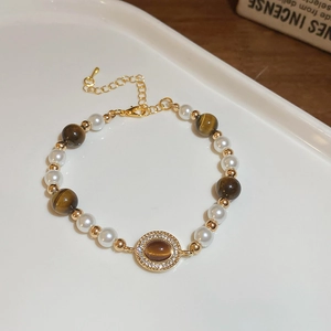 Vue détaillée du bracelet vintage avec œil de tigre brun, perles et perles dorées