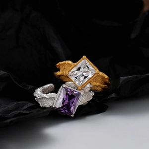 Detailed macro view of irregular lava texture rings with gold and silver rectangular stones
