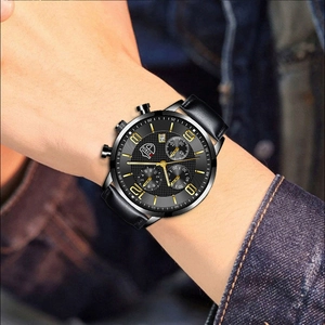 Détail de la montre à quartz pour homme avec bracelet en cuir noir sur fond en jean bleu