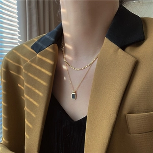 Double-layered gold titanium necklace with black rectangular pendant and Figaro chain