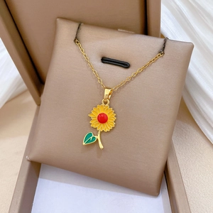 Gros plan d'un pendentif tournesol doré avec des pétales jaunes et cristaux sur un coffret