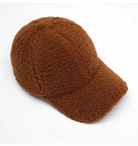 Gros plan sur la polaire sherpa marron et la visière courbée d'une casquette baseball
