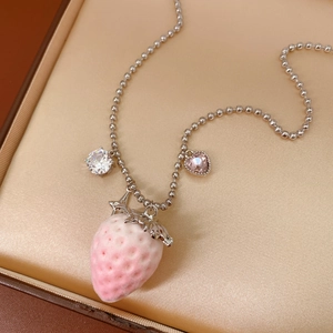 Silver bead chain necklace with pink strawberry pendant and gems on silk cushion