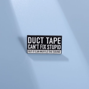Détail de l'épingle émaillée rectangulaire avec texte humoristique sur fond bleu ciel