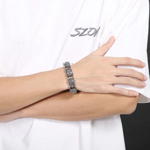 Close-up of vintage steel bracelet with engraved floral patterns on model's wrist