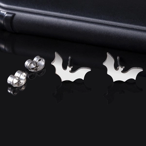 Minimalist silver bat stud earrings with butterfly backings on dark textured background