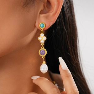 Detail view of vintage court-style earrings with turquoise, purple stones, and pearls