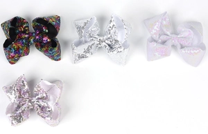 Flat lay of four 5-inch sequin hair bows in white, silver, lilac, and multicolor styles