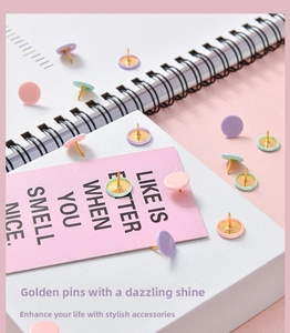 Detail of macaron color round thumb tacks with golden metal pins in a creative desk setting