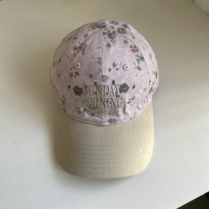 Détail de la casquette fleurie avec broderie dorée Sunday Morning et coutures vintage