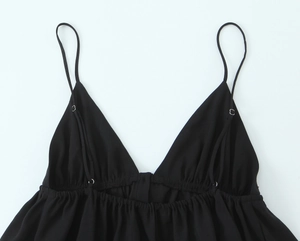 Detailed close-up of a black V-neck camisole top showing the light fabric and strap stitching