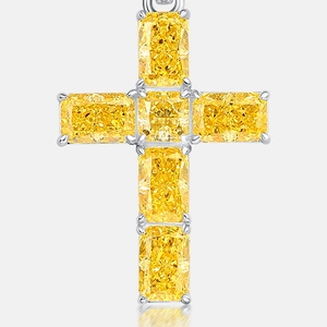 Cross pendant with yellow step-cut gemstones in silver claw setting on grey background