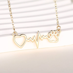 Detail of gold heart necklace featuring a heartbeat line and pet paw print pendant