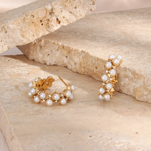Detailed shot of 18K gold plated C-shaped earrings with white pearls and zircons