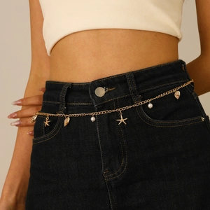 Bohemian gold waist chain with sea shells, starfish and pearls on denim jeans