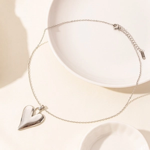 Macro detail of polished stainless steel heart pendant necklace with high mirror finish