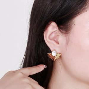 Gros plan sur des boucles d'oreilles tournesol dorées avec nacre sur une femme