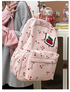 Dettaglio dello zaino in velluto rosa con ricamo a ciliegia e stampa a ciliegie