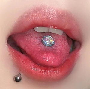Macro shot of surgical steel tongue ring with iridescent opal stone and metallic finish