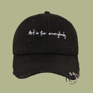Close-up of black distressed cotton baseball cap with iron rings and white embroidery