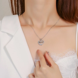 Silver hollow heart necklace with MAMA lettering and diamonds worn by model