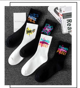 Close-up of black and white street style crew socks with colorful graffiti lettering