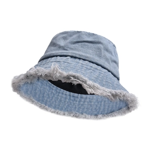 Close-up of light blue denim bucket hat featuring trendy distressed frayed edge details