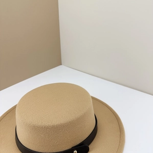 Detail of camel wool felt fedora with black leather strap and gold buckle accent