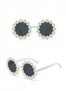 Detail view of daisy flower sunglasses with white frames and grey lenses for kids