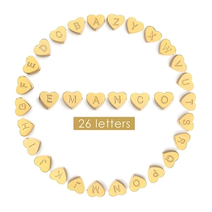 Macro view of gold heart-shaped charms featuring 26 letters for DIY jewelry making