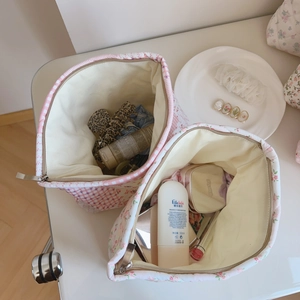 Détail de trousses à maquillage en coton matelassé rose à fleurs avec grand rangement