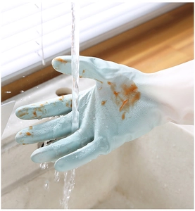 Close-up of blue textured rubber gloves being rinsed with water in a kitchen sink