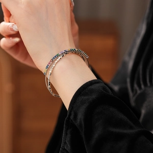 Macro shot of silver cuff bracelet with rainbow cubic zirconia on a model wrist