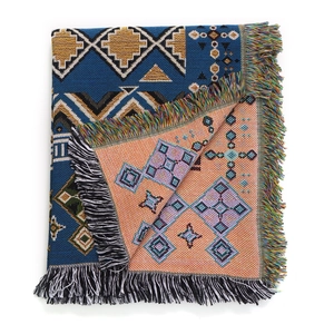 Detail of bohemian jacquard woven blanket showing blue geometric pattern and fringe edges