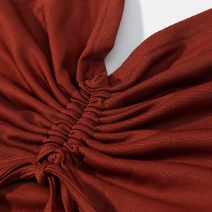 Close-up of the drawstring side detail and ruched knit fabric on the red mini dress