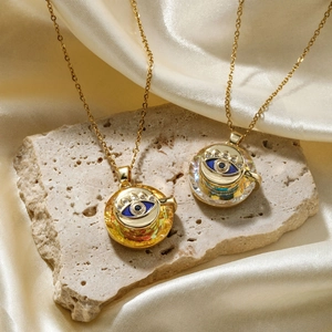 Fashionable evil eye crystal pendant necklace in gold finish on elegant silk background