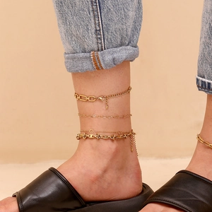 Close-up of 14K gold plated layered anklet set with minimalist chain patterns